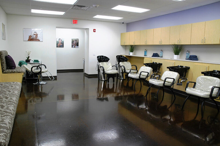 Modern hair salon interior with styling chairs and shampoo stations, clean design and bright lighting.