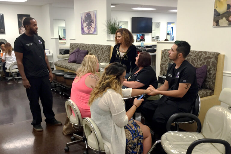People engaging in a conversation and nail care inside a salon, with cozy seating and decor.