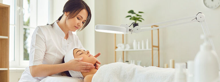 Esthetician performing a relaxing facial massage in a serene spa setting.