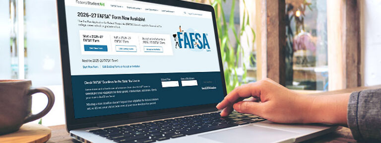 Person using a laptop to fill out the 2026-27 FAFSA form online, with a coffee cup nearby.